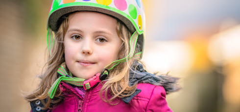 Ung flicka bär cykelhjälm