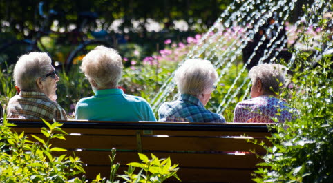 Äldre sittande på parkbänk.