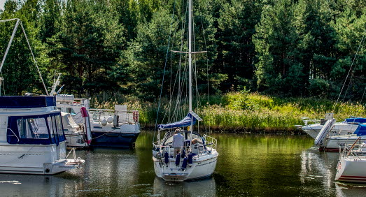 Segelbåt seglar iväg från en båthamn