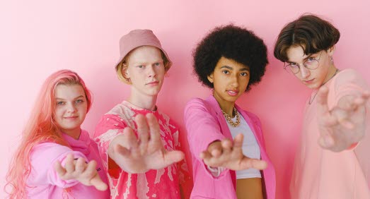 Ungdomar i rosa kläder mot rosa bakgrund