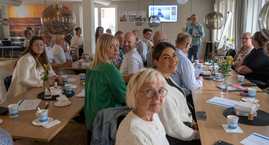 Grupp av sittande människor tittar in i kameran.