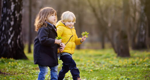 Två barn plockar vårblommor 