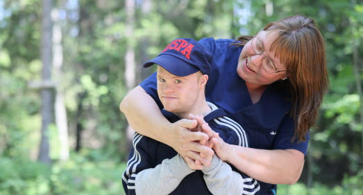Vårdare ute i skogen med boende. 