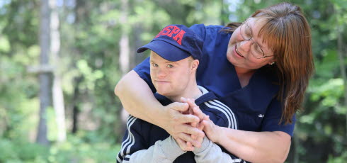 Vårdare ute i skogen med boende. 
